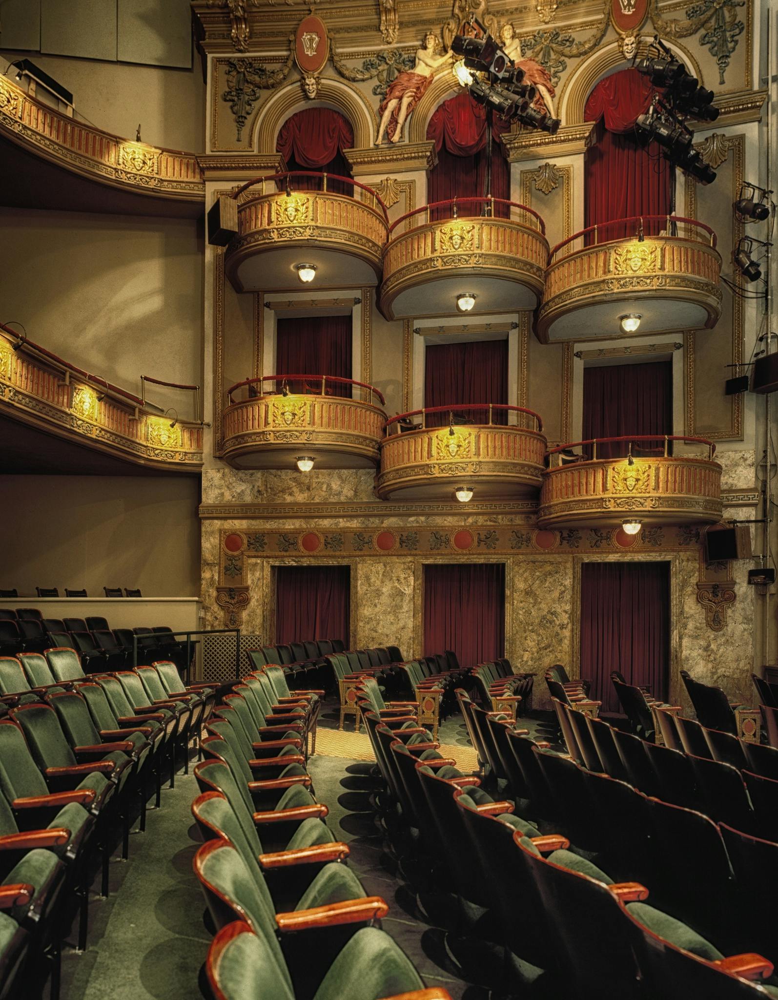 Classic theater interior featuring ornate balconies and empty seats, perfect for drama or performance themes.